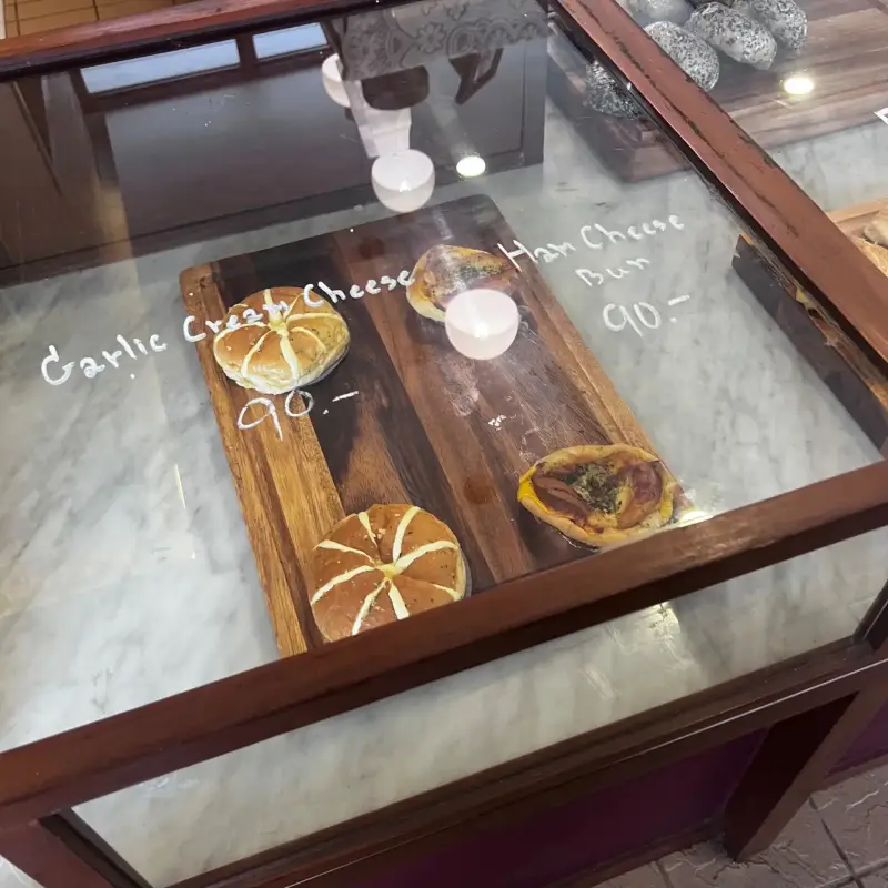 Runde und längliche Gebäckstücke auf Holzbrettern in der Vitrine
