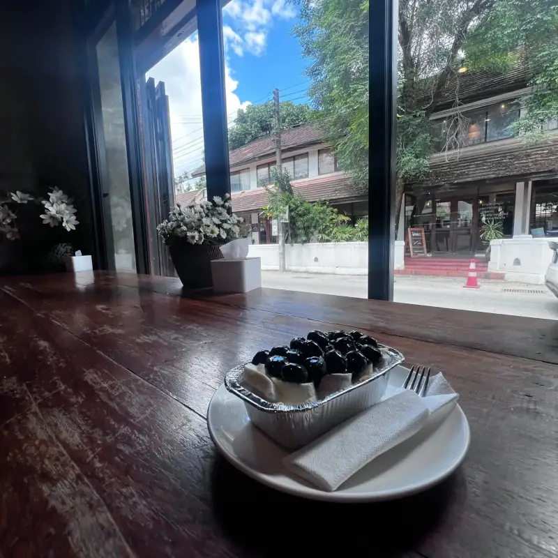 ขนมหวานหน้าเบอร์รี่บนเคาน์เตอร์ไม้หน้าหน้าต่างบานใหญ่