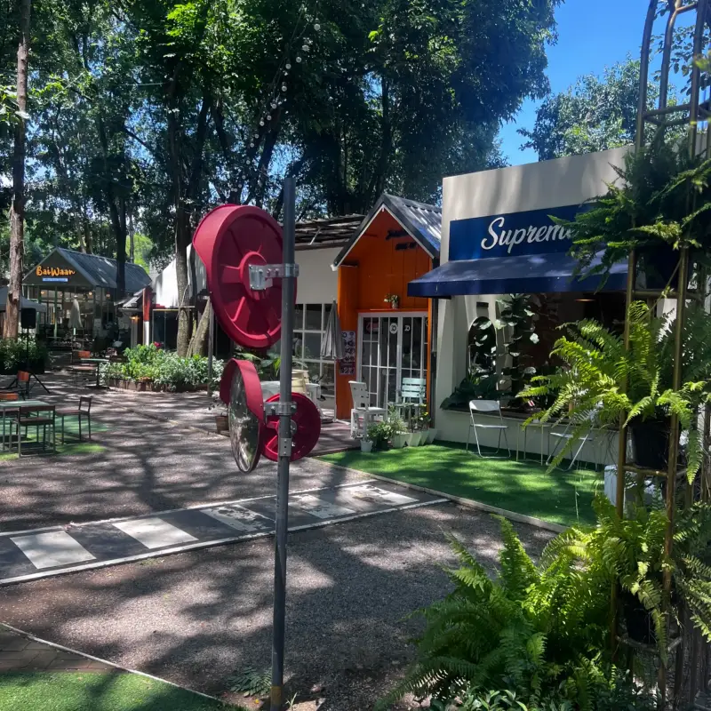Bunte kleine Fassaden und ein rotes Objekt aus großen Kreisen am Gartenweg