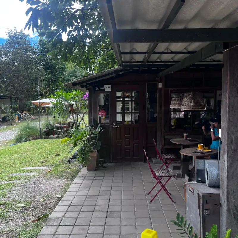 Überdachter Weg vor dem Café mit roten Klappstühlen