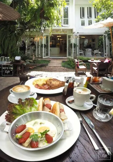 โต๊ะในสวนพร้อมอาหารและถ้วยกาแฟ หน้าอาคารสีขาว