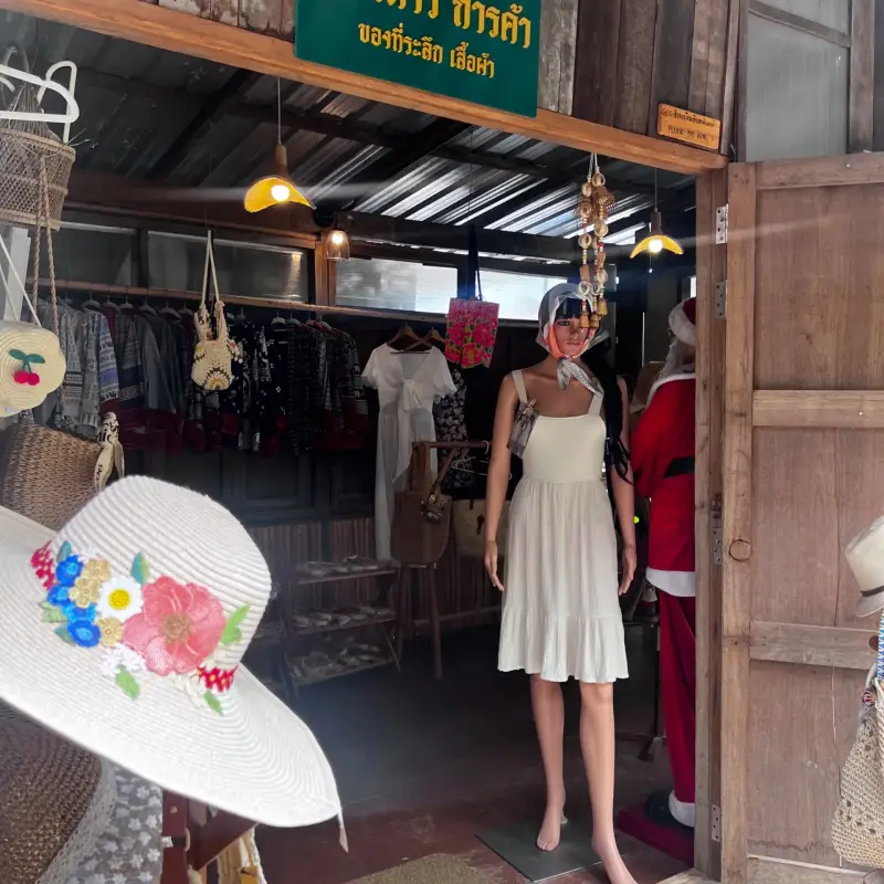 Hats, clothing and a mannequin outside a small shop