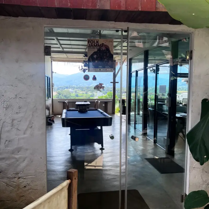 View through a glass door into a room with a large mountain-facing window