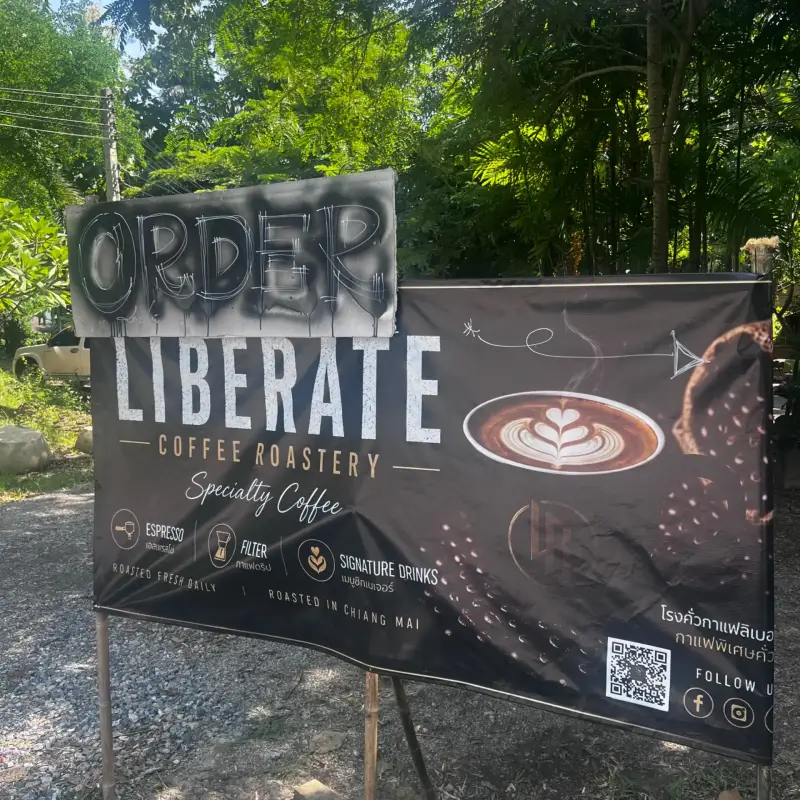 Liberate-Schild mit Bestellhinweis und einer abgebildeten Kaffeetasse