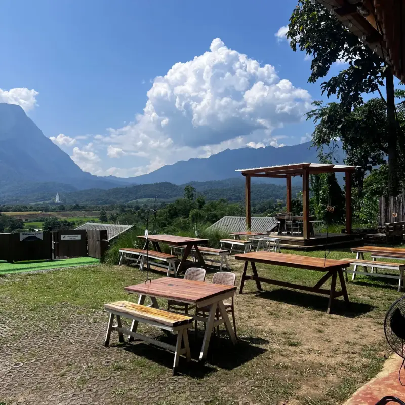 Garden tables and benches against a broad mountain backdrop