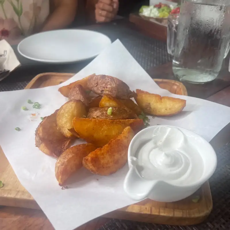 Goldbraune Kartoffelspalten mit einem hellen Dip