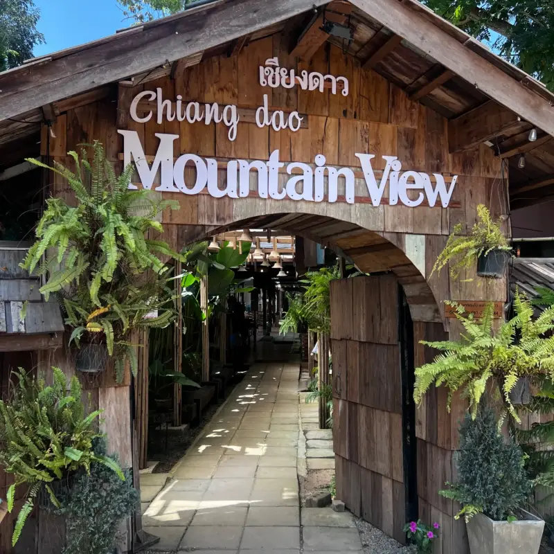 Hölzernes Eingangstor mit Mountain-View-Schriftzug und hängenden Pflanzen