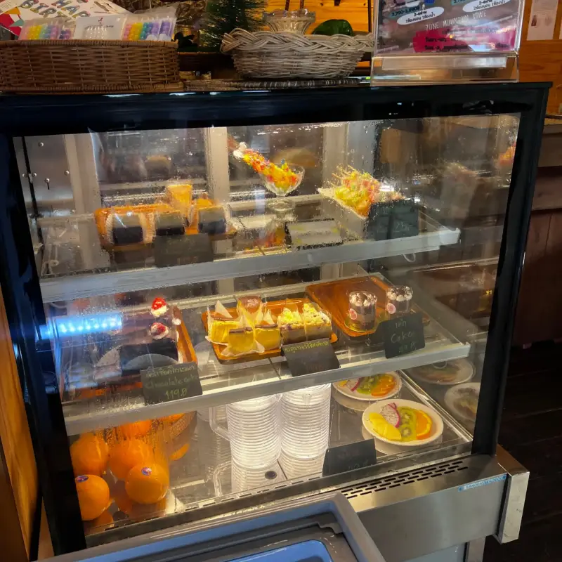 Refrigerated display with small desserts, drinks and tableware
