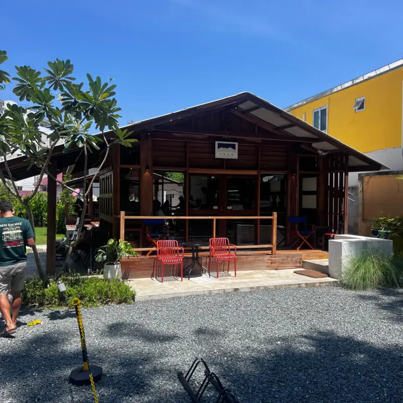 Small wooden building with red chairs on the veranda