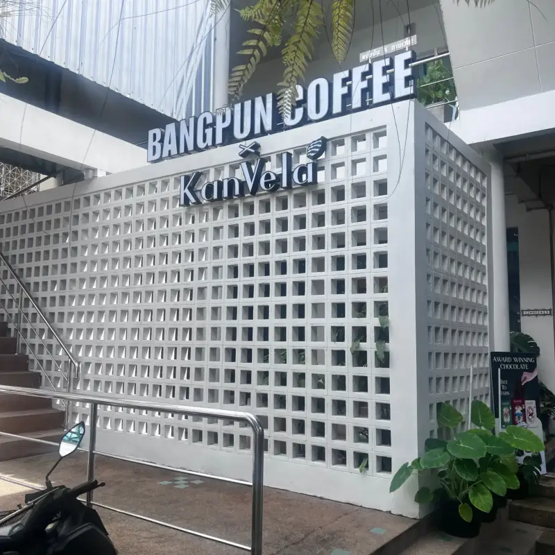 ป้าย Kanvela และ Bangpun Coffee บนผนังช่องลมสีขาว
