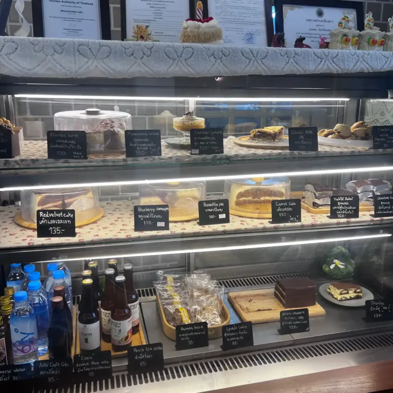 Kühlvitrine mit verschiedenen Kuchen, Desserts und Getränken